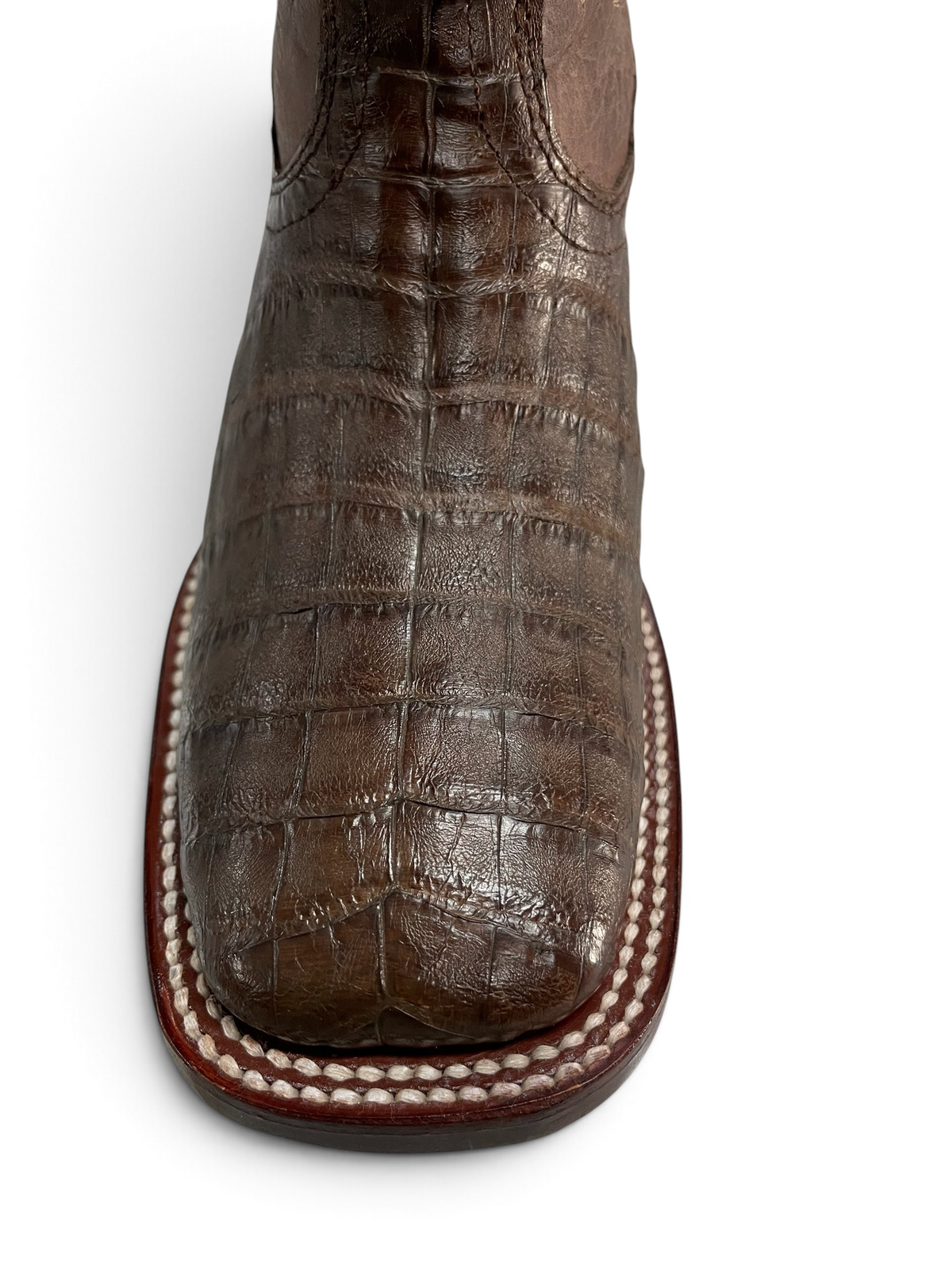 Botas vaqueras Botas El Pistolero PYP de piel de cocodrilo marrón con punta cuadrada y costuras artesanales visibles.