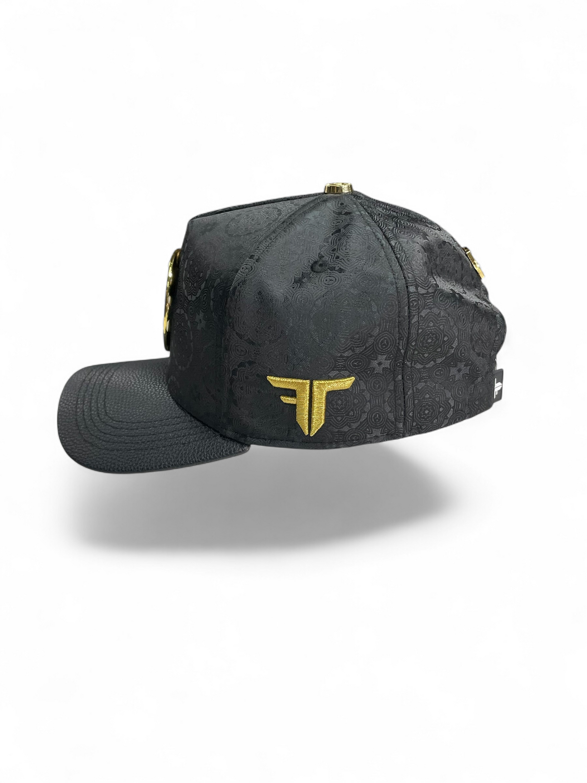 Gorra Botas El Pistolero PYP negra con patrón grabado, visera de piel sintética y logo lateral dorado en exhibición.