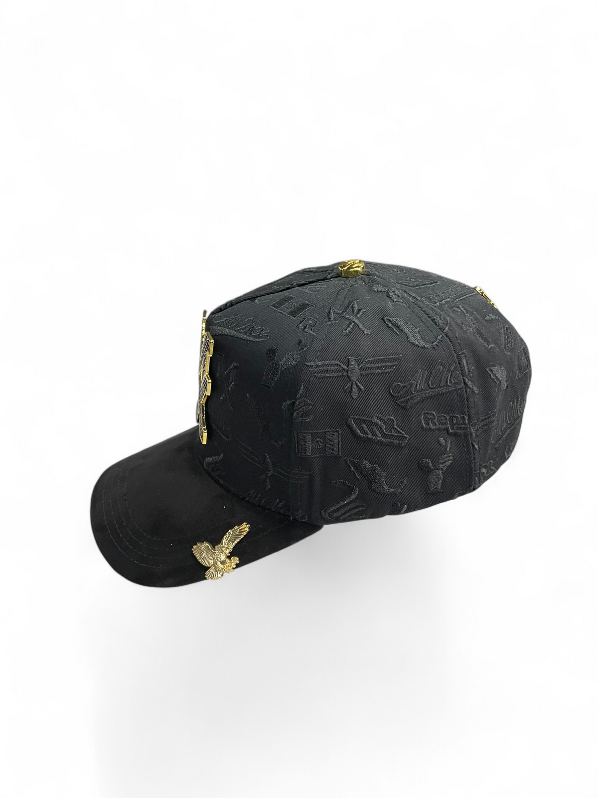 Gorra Botas El Pistolero PYP negra con patrón grabado, emblema metálico dorado y detalle de águila en la visera.