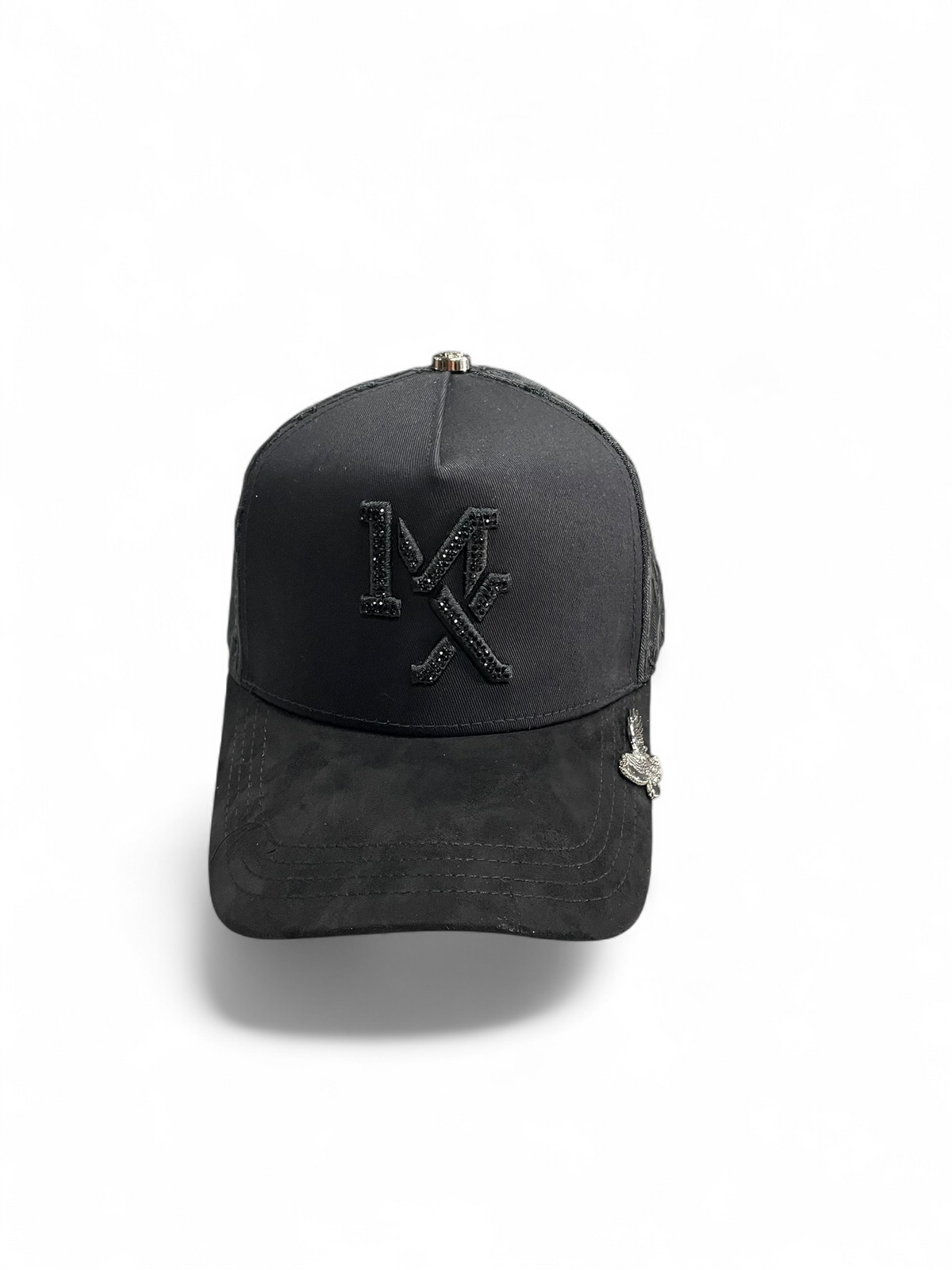 Gorra Botas El Pistolero PYP negra con visera de gamuza, logo bordado brillante y pin metálico de águila lateral.